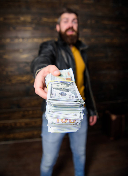 Mafia business. Man brutal bearded hipster wear leather jacket and hold cash money. Illegal profit and black cash. Guy mafia dealer with cash profit. Man give cash money bribe. Richness and wellbeing - Photo, image