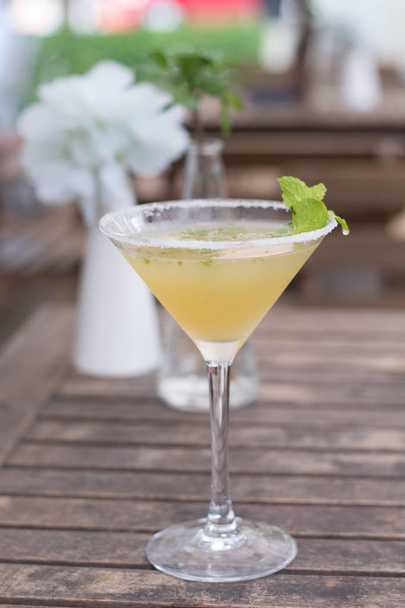  A cocktail  of Tequila, lime, mint leaves, and passionfruit - Fotó, kép