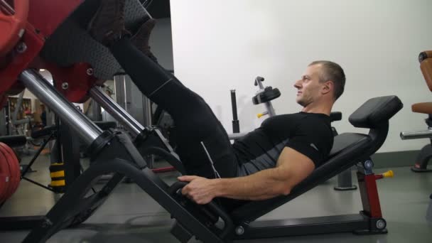 The athlete shakes his legs on the simulator 4K Slow Mo - Footage, Video