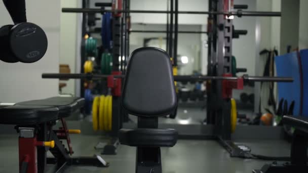El atleta con pesas se sienta en un banco, hace un ejercicio para dos manos 4K Slow Mo
 - Imágenes, Vídeo