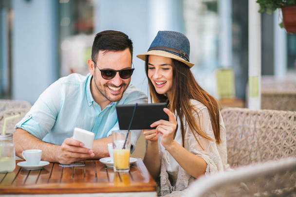 幸せな若いカップルのカフェで座っている間オンライン ショッピング - 写真・画像