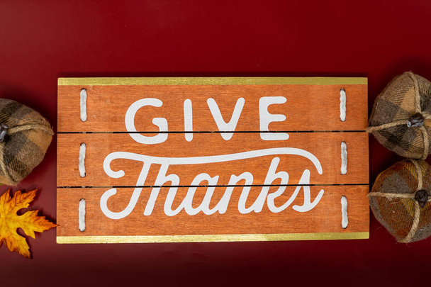 Give Thanks text phrase Thanksgiving holiday background with plaid pumpkins. Orange, white and red colors - Photo, image