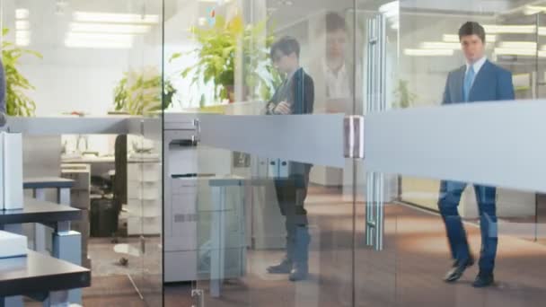 In the Big Office Associate Brings Important News to His Manager, Shows Tablet Computer with Information. Modern Glass and Concrete Building is Full of Busy Business People. - Video
