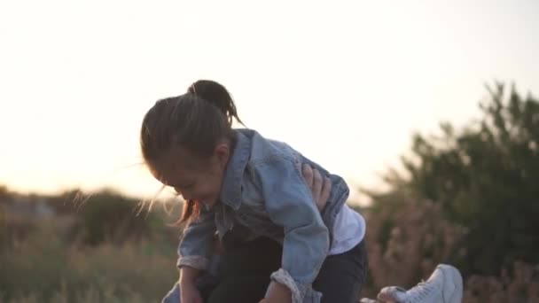 Sekarotuinen perhe, eurooppalainen äiti ja aasialainen tytär viettävät aikaa puistossa auringonlaskun aikaan. He leikkivät maassa ja hymyilevät. Lämmin kevät tai kesäkausi
 - Materiaali, video