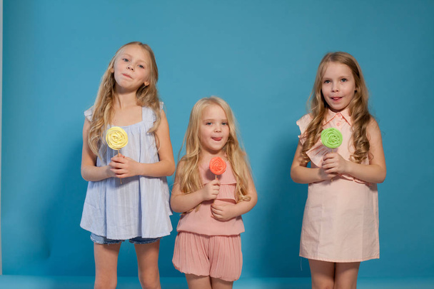 kolme tyttöystävää siskot syövät makeaa tikkaria makealla suklaajälkiruoalla
 - Valokuva, kuva