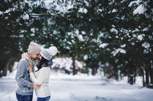 man and girl in sweaters hugging in the park in winter. winter walk, rest. - Foto, afbeelding