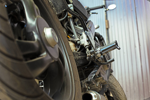 Обрізаний крупним планом знімок красивого і нестандартного мотоцикла в майстерні
 - Фото, зображення