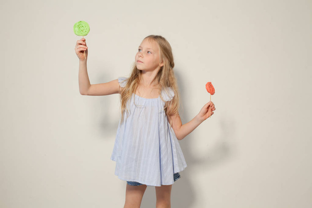 egy lány tart a kezében a két candy édes nyalóka - Fotó, kép