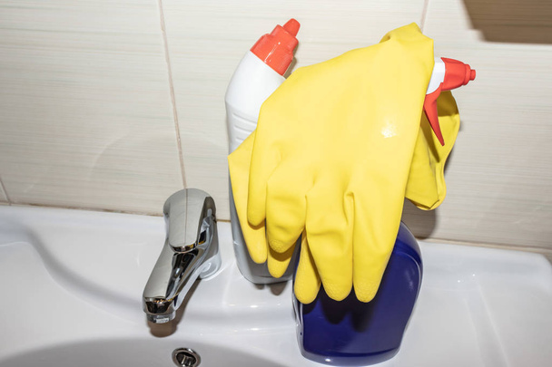 Modern detergents and cleaning and washing supplies on bathroom sink. - Фото, изображение