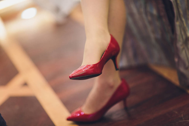 Close-up bijgesneden foto van mooie benen van de zakelijke dame in hoge heuvels schoenen. Ze zit in het kantoor. - Foto, afbeelding