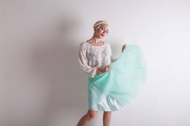 hermosa mujer rubia en una boina y un vestido brillante sobre un fondo blanco
 - Foto, Imagen