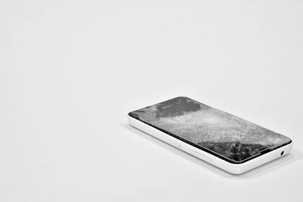 Cell phone with the screen broken by a hammer - Φωτογραφία, εικόνα