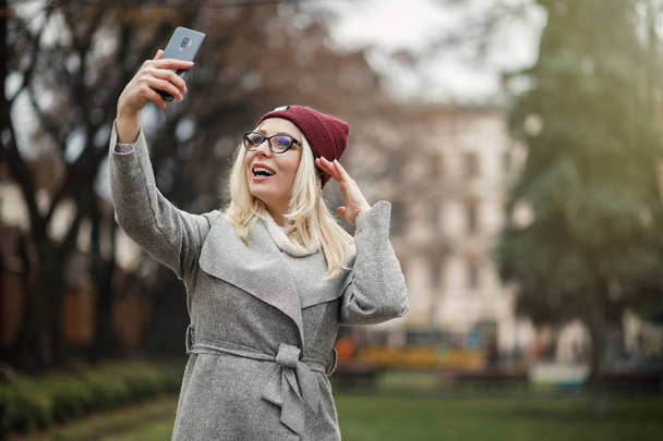 Beautiful woman using a modern smartphone in the city. - Foto, Bild