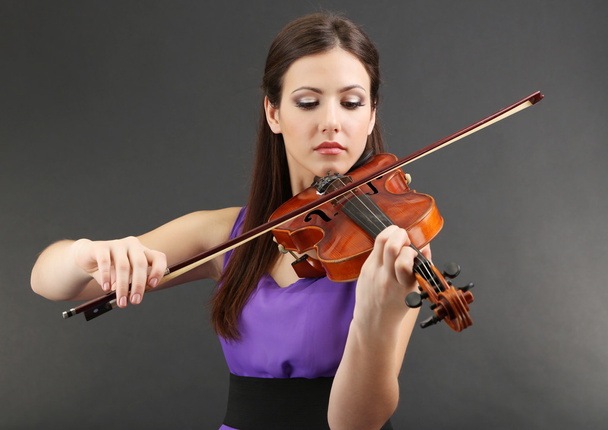 Beautiful young girl with violin on grey background - Фото, зображення