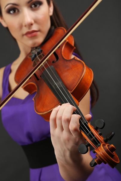 Beautiful young girl with violin on grey background - Фото, зображення