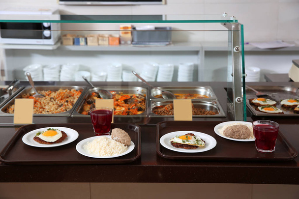 Bandejas con comida saludable en la línea de servicio en la cantina de la escuela
 - Foto, imagen