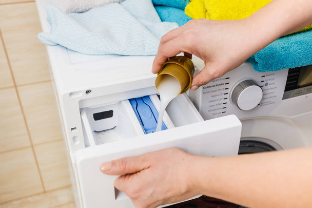 Washing powder detergent and measuring cup pouring into machine. Household duties, clothes laundry obejcts concept. - Photo, Image