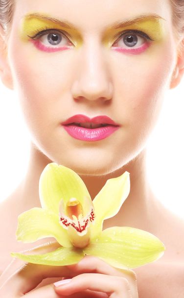 Nuori nainen kirkas meikki tilalla orkidea
 - Valokuva, kuva