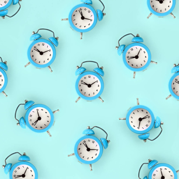Piso yacía retro hermoso reloj despertador nuevo sobre fondo de color azul. Patrón mínimo. Vista superior. Perder el tiempo concepto
 - Foto, imagen