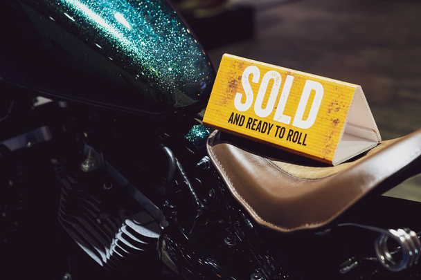 Nahaufnahme des Schildes "verkauft und rollbereit" auf dem Motorrad - Foto, Bild