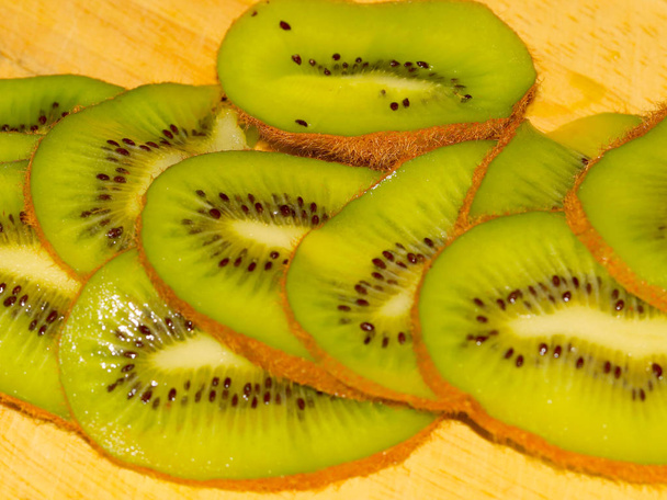 sliced tropical kiwi fruit on a wooden cutting board - Foto, Imagen