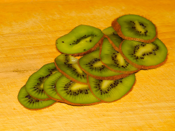 sliced tropical kiwi fruit on a wooden cutting board - Foto, Imagen