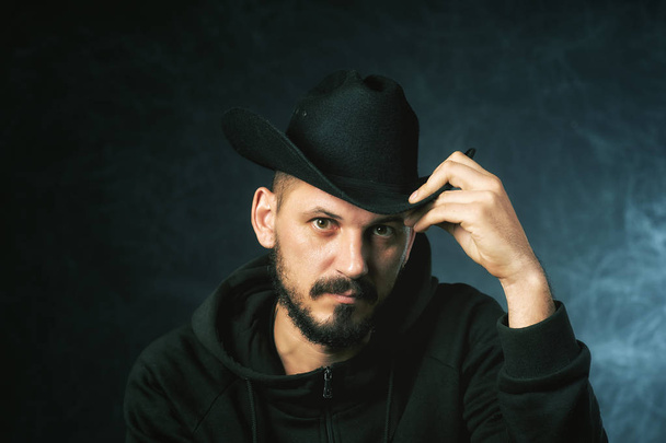 Studiový Portrét muže v klobouku se širokou krempou na tmavém pozadí - Fotografie, Obrázek