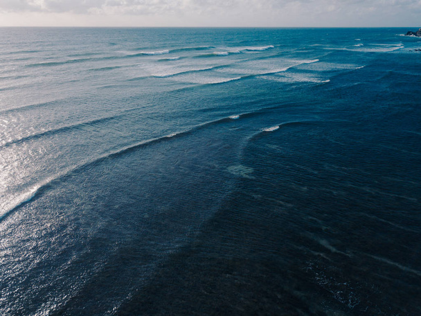 Aerial view beautiful of sea waves from drone. Stock image picture of blue color ocean water, wave, sea surface. Top view on turquoise waves, clear water surface texture. Top view, amazing nature background - Fotografie, Obrázek