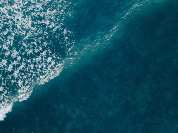 Aerial view beautiful of sea waves from drone. Stock image of blue color of ocean water, sea surface. Top view on turquoise waves, clear water surface texture.  Top view, amazing nature background - Photo, Image