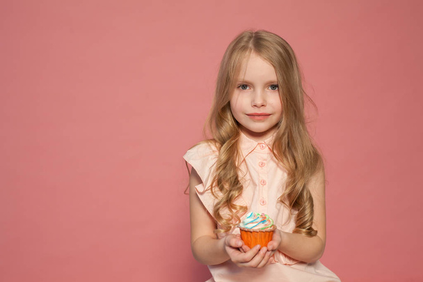 mała dziewczynka, w ręku trzyma cukierki słodkie ciastko ciasto - Zdjęcie, obraz