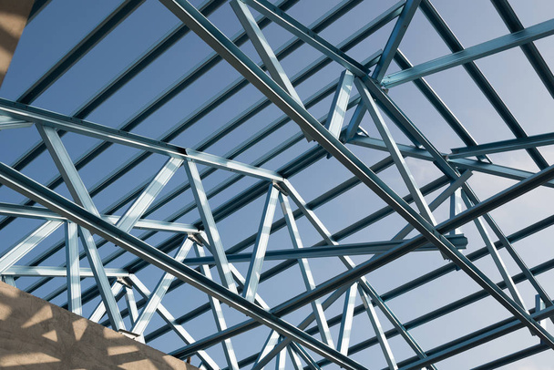 Structure of steel roof frame for building construction isolated on blue sky background. - Photo, Image