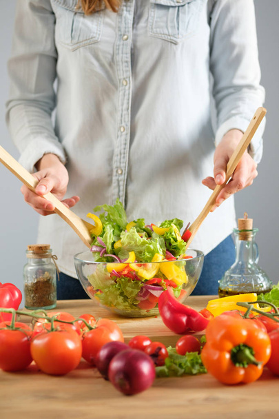 The girl prepares a vegetable salad. Vertical photo - Foto, Imagem