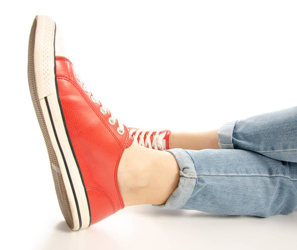 Woman legs feet jeans red sneakers hipster style, side view - Фото, изображение