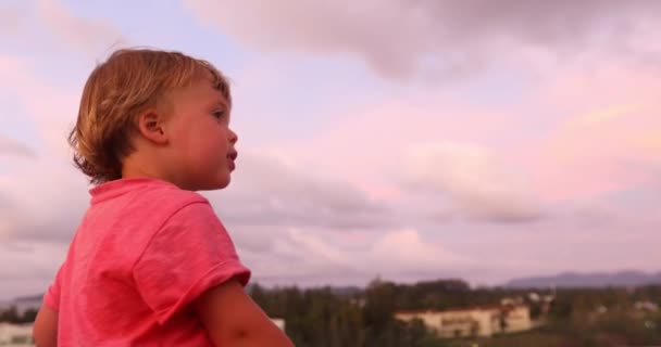 Uroczy chłopak w zachód słońca patrząc od hotelu - Materiał filmowy, wideo