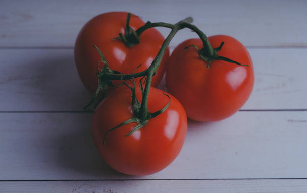 Red, juicy tomatoes on wooden background, concept: fresh vegetables, healthy food. - Фото, изображение