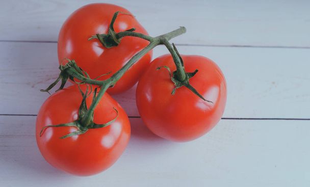 Red, juicy tomatoes on wooden background, concept: fresh vegetables, healthy food. - Valokuva, kuva