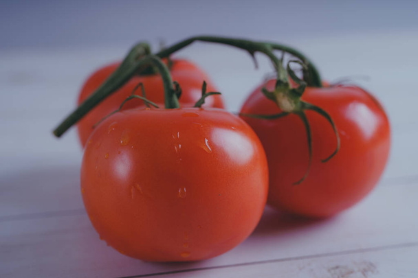 Red, juicy tomatoes on wooden background, concept: fresh vegetables, healthy food. - Photo, image