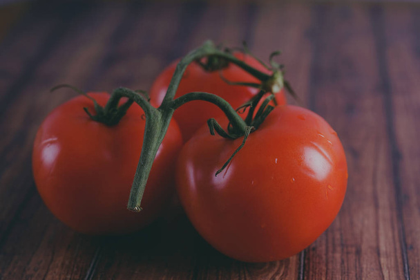 Red, juicy tomatoes on wooden background, concept: fresh vegetables, healthy food. - Foto, Imagen