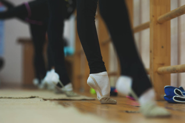 Close up of feet of girl stretching tip toe in gym - Foto, imagen