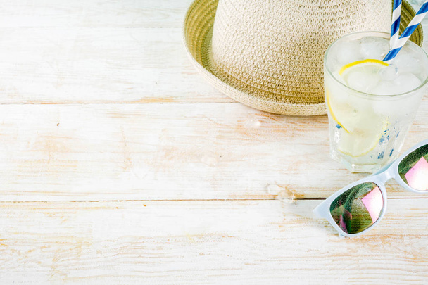 Summer holidays vacation concept background, hat, sunglasses, iced drink (lemonade, mojito), white wooden background copy space  - 写真・画像