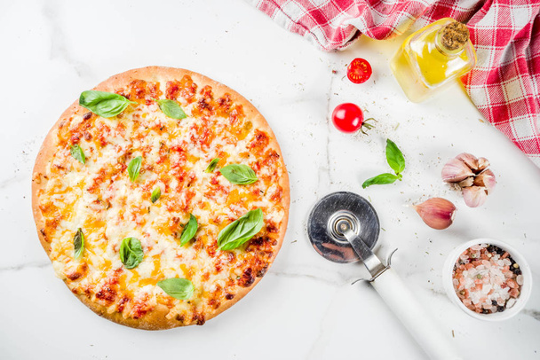 Domácí krájený kýčovité klasická italská pizza s přísadami a olivový olej, bílé mramorové pozadí kopie prostoru pohled shora - Fotografie, Obrázek