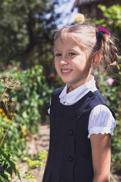 Cute little girl in a garden in the countryside. - Foto, afbeelding