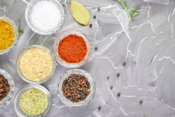 Seasoning background. Spice and herb seasoning with fresh and dried herbs and spices in bowls. Colourful various herbs and spices for cooking on grey background. Top view. Copy space - Photo, Image
