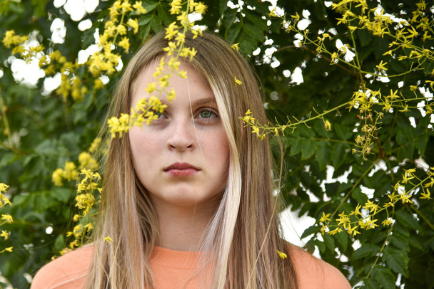 Portrait of a girl under a flowering tree yellow - Фото, зображення