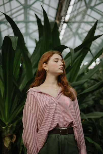 jeune femme sensuelle en chemise rayée posant parmi les plantes vertes
  - Photo, image