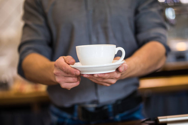 Barista prepares cappuccino in his coffee shop - Photo, Image