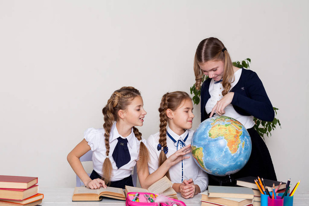 three schoolgirls girls learn world geography lesson map - Photo, Image