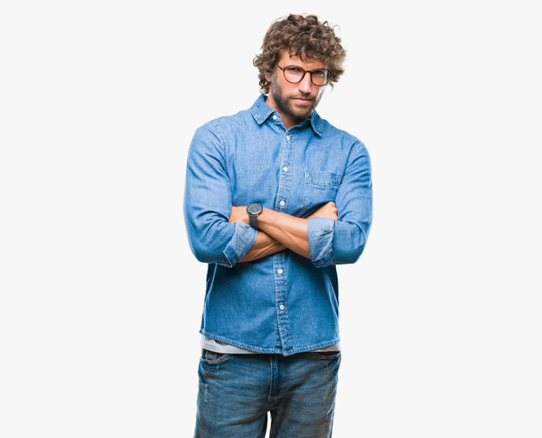 Pohledný model hispánský muž nosí brýle izolované pozadí skeptik a nervózní, nesouhlasným výrazem na tváři s překřížením rukou. Negativní osoba. - Fotografie, Obrázek
