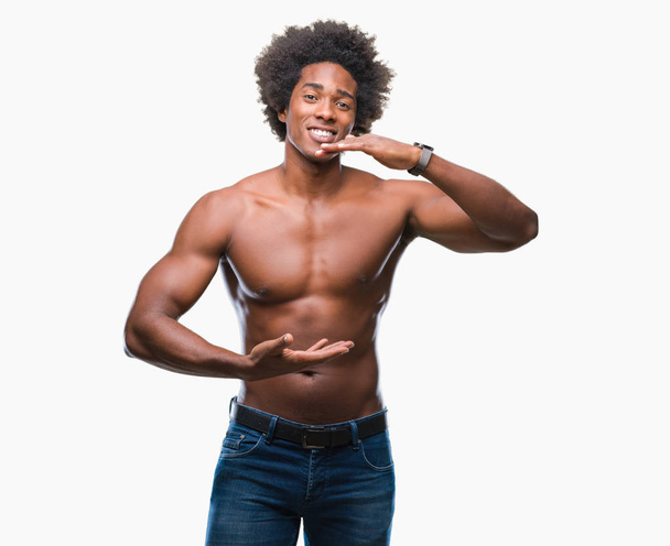 Afro Amerikaanse shirtless man naakt lichaam tonen over geïsoleerde achtergrond gebaren met de handen tonen grote en grote grootte teken, symbool van de maatregel. Glimlachend kijken naar de camera. Meten concept. - Foto, afbeelding