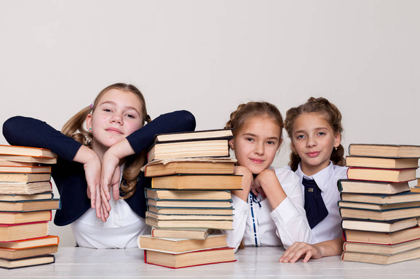 trzy dziewczyny uczennice przy biurku z książek na lekcji w szkole - Zdjęcie, obraz